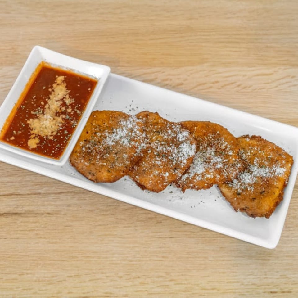 Three golden-brown fried dough pieces dusted with powdered sugar and spices, served with a side of red sauce.