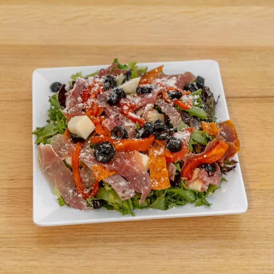 Pizza 54's fresh salad with prosciutto, roasted red peppers, black olives, and parmesan cheese.